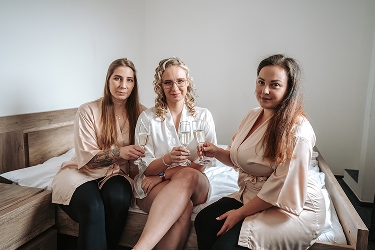 Nevěsta se svědkyní a družičkou při přípitku